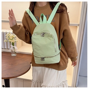 Détail d'un sac à dos en nylon vert menthe avec double fermeture éclair et sangles tissées