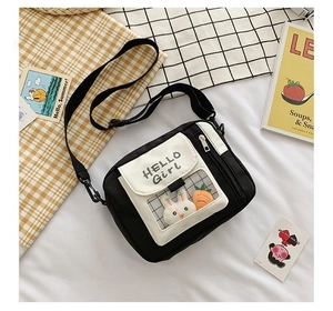 Détail du sac bandoulière en toile avec poche transparente, lapin en peluche et texte HELLO Girl