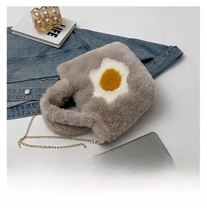 Detail showing plush gray crossbody bag with fried egg decor and golden chain strap