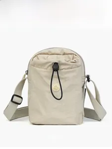 Dettaglio frontale borsa a tracolla in nylon beige con tasca a coulisse ed etichetta nera