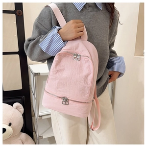 Vue latérale du sac à dos en nylon rose avec doubles poches zippées sur un mannequin