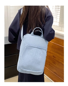 Dettaglio borsa in nylon azzurro stropicciato con texture e tasca frontale con cerniera
