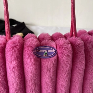 Dettaglio della borsa in peluche rosa con texture in ecopelliccia e etichetta moda
