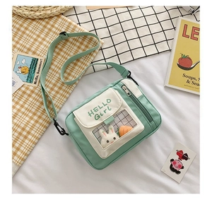 Vue détaillée du sac en toile vert menthe avec fenêtre transparente et peluche de lapin