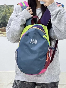 Detailed view of water-resistant nylon backpack with colorful contrast patchwork and side pockets