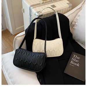 Detail of French quilted underarm bags in black and white on a modern sofa set