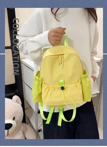 Detail eines leichten gelb-neongrünen Nylon-Rucksacks mit Kordelzug und Taschen