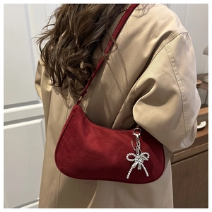 Vue détaillée d'un sac baguette vintage en daim bordeaux avec breloque nœud argenté