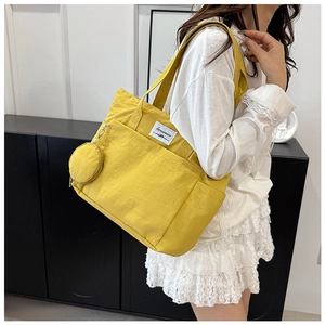 Detail view of bright yellow canvas tote bag with side pocket and small round coin purse