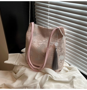 Close-up of pink brocade tote bag with traditional Chinese embroidery and silk tassel
