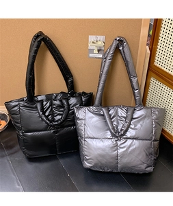 Detail of quilted puffer tote bags in black and silver waterproof nylon material
