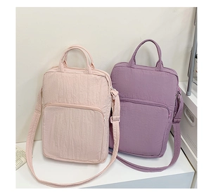 Dettaglio delle borse tote in tessuto Oxford rosa e viola con tracolle regolabili