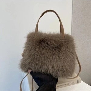 Dettaglio borsa in pelliccia sintetica marrone con manici in pelle e catena di perle