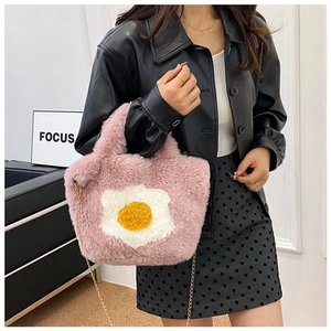 Detail showing plush pink handbag with fried egg design and gold chain strap