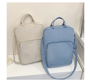 Dettaglio delle borse tote in tessuto Oxford di grande capacità nei colori beige e azzurro