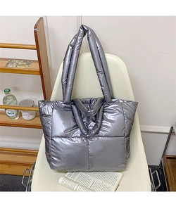 Detail of silver quilted puffer tote bag with metallic finish and dual carrying handles