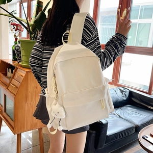 Detail view of cream canvas backpack with a cute cloud plush pendant for students