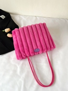 Dettaglio della borsa tote in pelliccia sintetica rosa con trapuntatura e logo viola