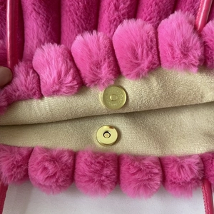 Dettaglio della borsa tote in peluche rosa con fodera beige e chiusura magnetica dorata