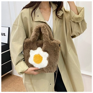 Close-up of fluffy brown plush crossbody bag with fried egg design and chain strap