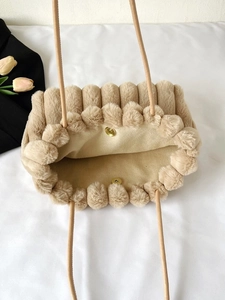 Dettaglio della borsa in peluche con chiusura magnetica dorata e fodera morbida