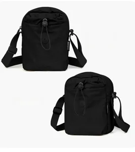 Dettaglio della borsa a tracolla in nylon nero con coulisse e logo alla moda