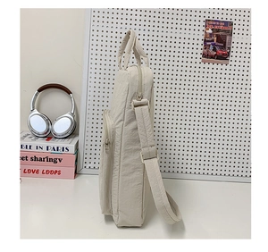 Vista laterale della borsa tote beige in tessuto oxford con scomparti con cerniera