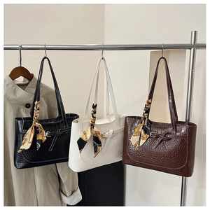 Detailed display of large crocodile pattern tote bags in black, white and coffee brown
