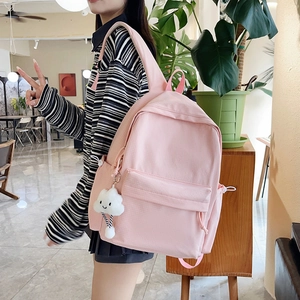 Detailed texture of pink waffle pattern backpack featuring a cute white cloud plush pendant