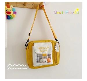 Détail du sac bandoulière en toile jaune avec fenêtre PVC et peluche de lapin incluse