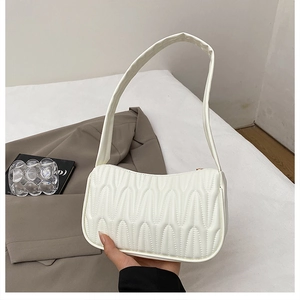 Detail showing the wave quilted texture and zipper closure on a white French underarm bag