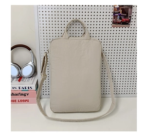 Dettaglio della borsa tote beige in tessuto oxford trapuntato con manico e tracolla