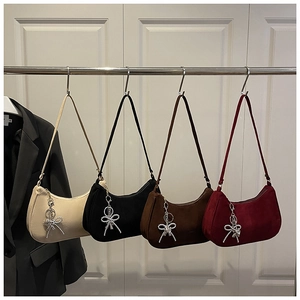 Détail de quatre sacs hobo en texture mate avec des breloques noeud en perles élégantes