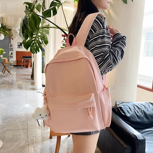 Detail of light pink backpack with textured fabric and a cute white cloud charm