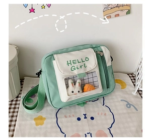 Détail du sac en toile vert menthe avec imprimé HELLO Girl et joli lapin en peluche