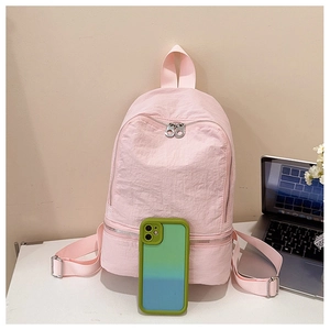 Gros plan détaillé d'un sac à dos rose en nylon avec deux compartiments zippés et texture