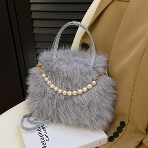 Dettaglio borsa grigia in pelliccia sintetica con catena di perle e finiture in metallo oro