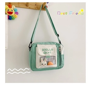 Détail du sac bandoulière en toile vert menthe avec une fenêtre transparente