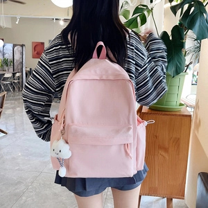 Detail of pink backpack featuring textured fabric and a cute white plush cloud charm