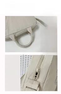Dettaglio dei manici imbottiti e della cerniera fluida della borsa per laptop in nylon
