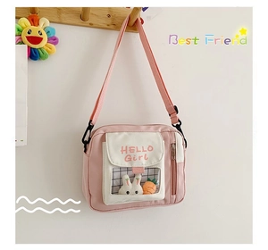 Détail d'un sac bandoulière en toile rose avec texte HELLO Girl et fenêtre lapin mignon