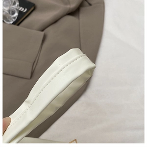 Detailed close-up showing fine double stitching and creamy white PU leather texture on strap