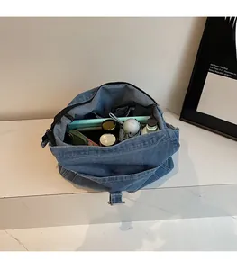 Detail view showing large interior capacity of this vintage denim tote bag with items
