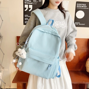 Detail of light blue waterproof nylon backpack with a cute plush cloud charm