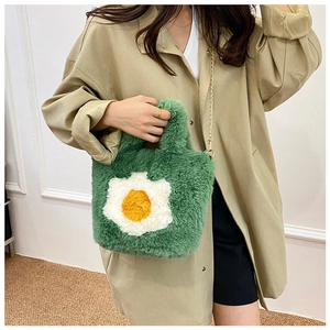 Close-up of green plush crossbody bag featuring unique fried egg pattern and gold chain