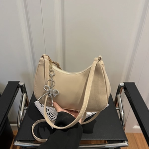 Sac à bandoulière baguette minimaliste en similicuir beige mat avec pendentif nœud