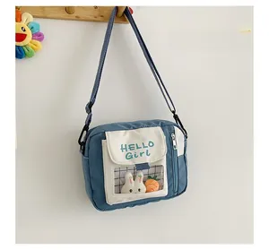Détail du sac bandoulière en toile avec imprimé Hello Girl et fenêtre lapin en peluche
