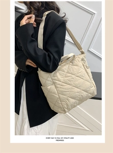 Close-up of beige quilted tote bag showing diamond stitching and adjustable shoulder strap