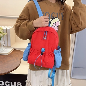 Detailansicht des roten Nylonrucksacks mit blauen Seitentaschen und Kordelzug