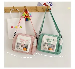 Détail de sacs bandoulière en toile avec fenêtre transparente et peluches de lapin mignonnes